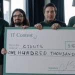 Start-up Victory - Winning Team of IT Developers Posing with a Huge Cheque Placard