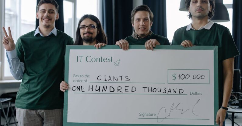 Start-up Victory - Winning Team of IT Developers Posing with a Huge Cheque Placard