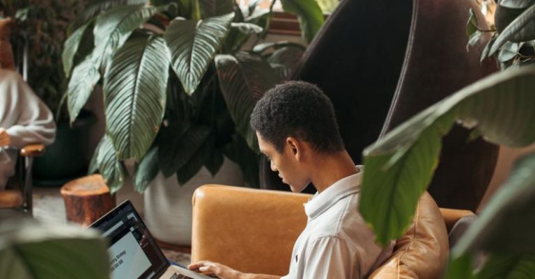Tech Innovation - Man in White Dress Shirt Sitting on Brown Chair