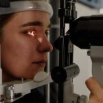 Business Vision - Woman testing vision on microscope