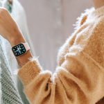 Customer Centric - Back view of unrecognizable dark haired female in jeans choosing clothes near rack