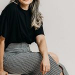 Business Expansion - A woman sitting on a white box with her legs crossed