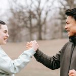 Positive Mindset - Young positive Asian trainer supporting and giving hand to woman